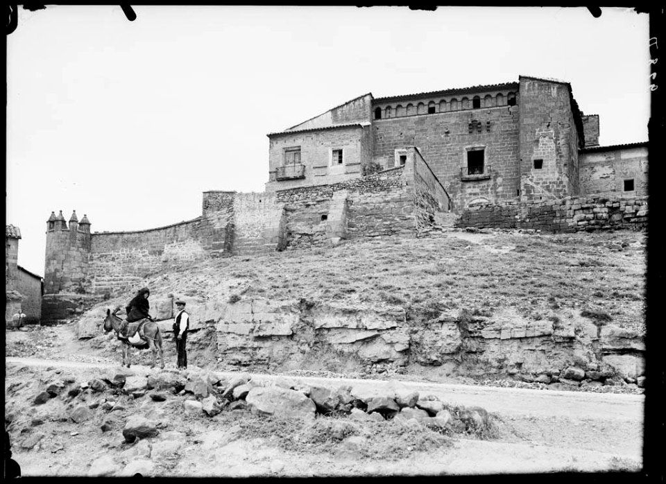El castell dels Abarca de Bolea a Siétamo amb una dona muntada en un ruc i un home en primer terme