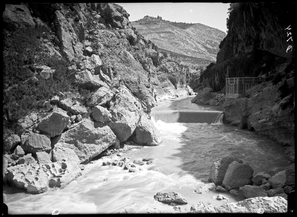El canal d'Aragó i Catalunya amb una caseta de la presa i el poble de la Puebla de Castro al fons