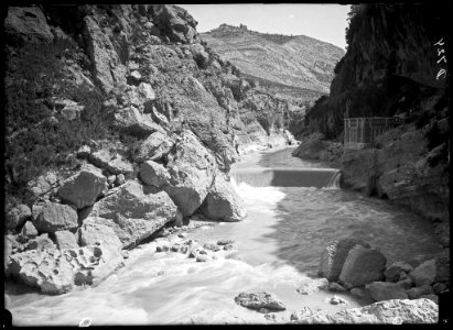 El canal d'Aragó i Catalunya amb una caseta de la presa i el poble de la Puebla de Castro al fons