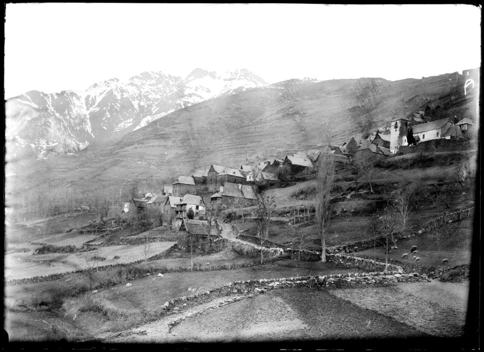 El poble de Bausen, a la Vall d'Aran i unes muntanyes nevades al fons