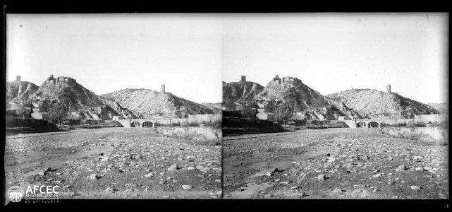 El poble de Castellfollit de Riubregós amb un pont en primer terme i al fons el castell i les torres del Balet i del Ballester