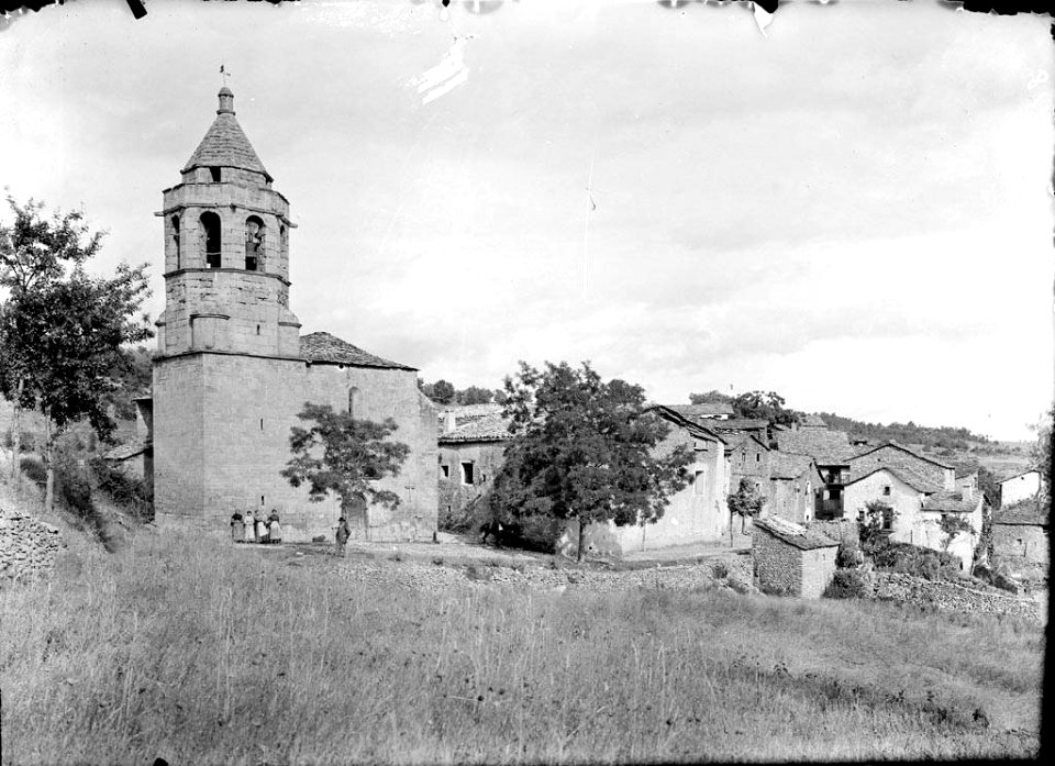 El poble de Castigaleu amb l'església i un grup de persones