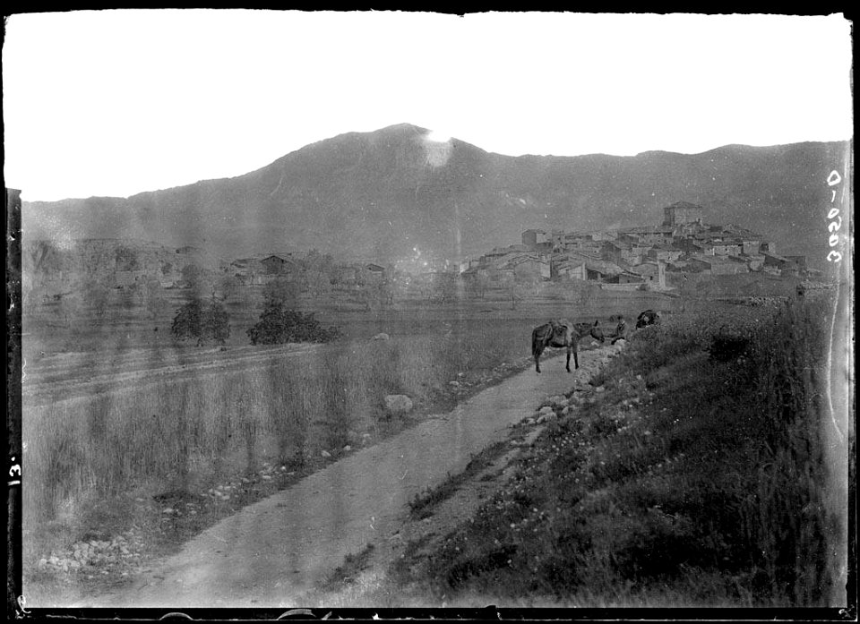 El poble de Sant Romà d'Abella i un home i un cavall en primer terme