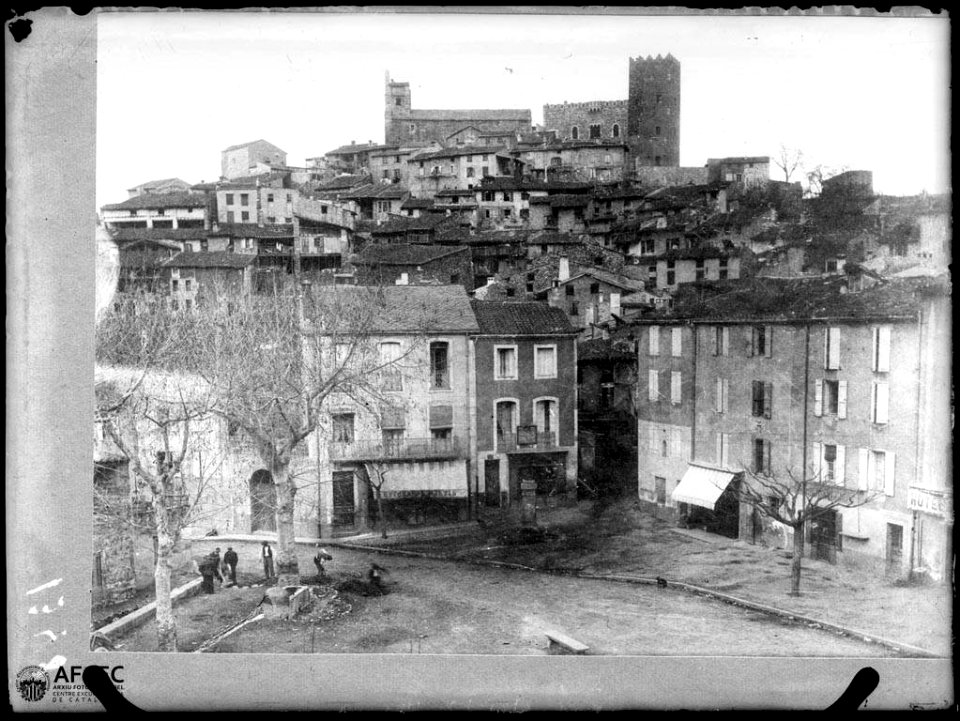 El poble de Vernet amb una plaça amb gent en primer terme