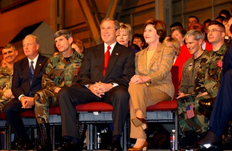 George W. Bush and Laura Bush sit together on the stage before a full house in Hangar 3 at Elmendorf Air Force Base, Alaska