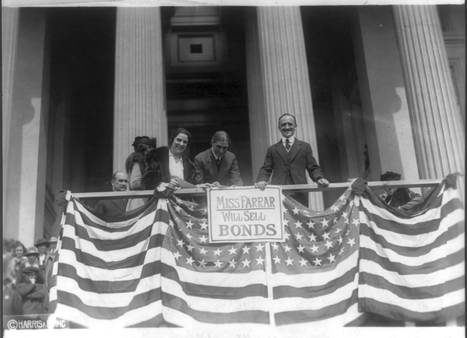 Geraldine Farrar and Secretary McAdoo selling war bonds on flag draped platform LCCN2016649412