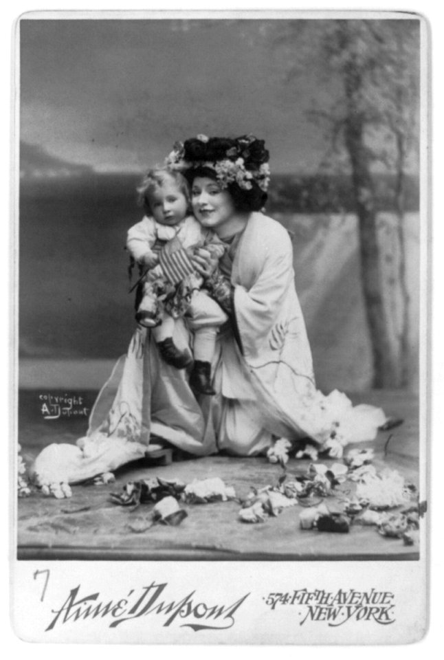 Geraldine Farrar, 1882-1967, full length, kneeling, facing left; in the role of Madame Butterfly, wearing Oriental costume and holding a small child LCCN2005683735
