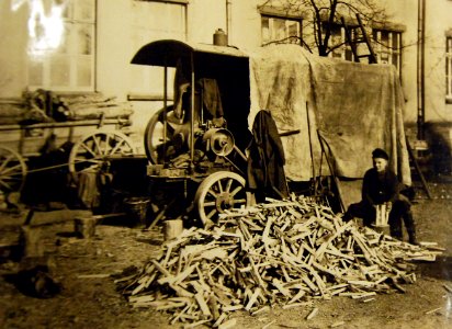 German boy splitting wood along with power saw (32140188252)