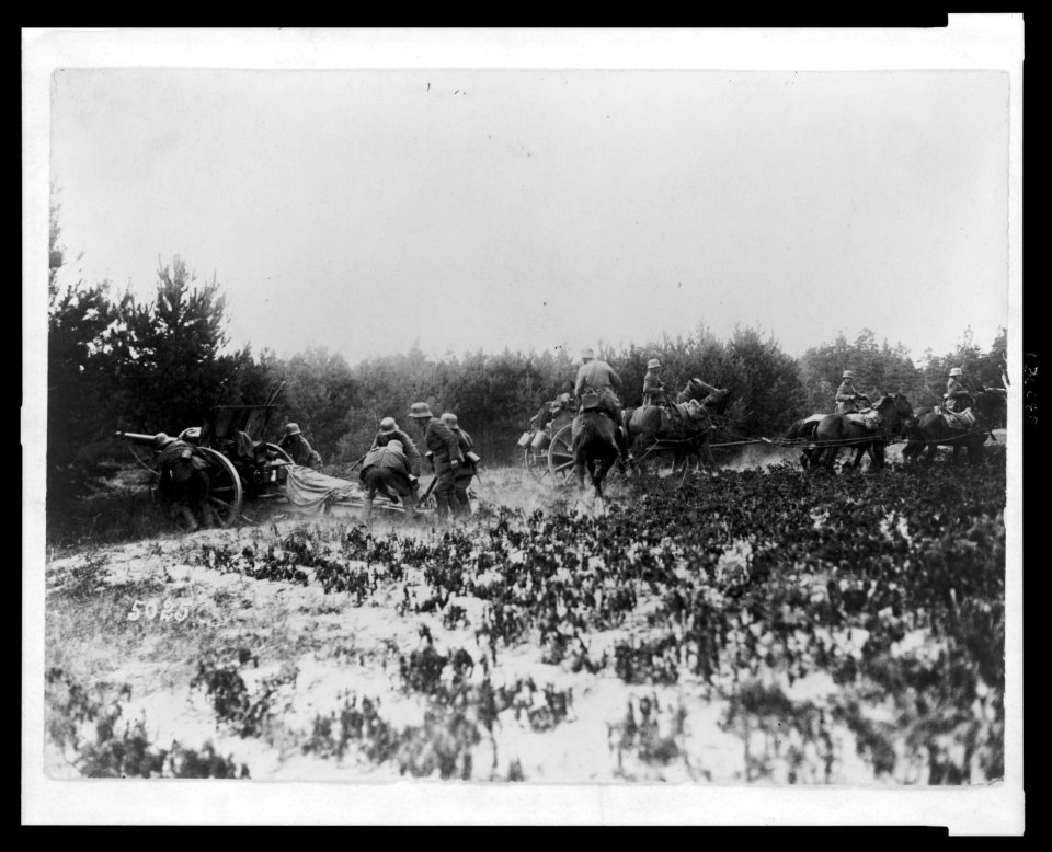 German soldiers firing artillery gun while other soldiers on horseback move a wagon LCCN2005697194