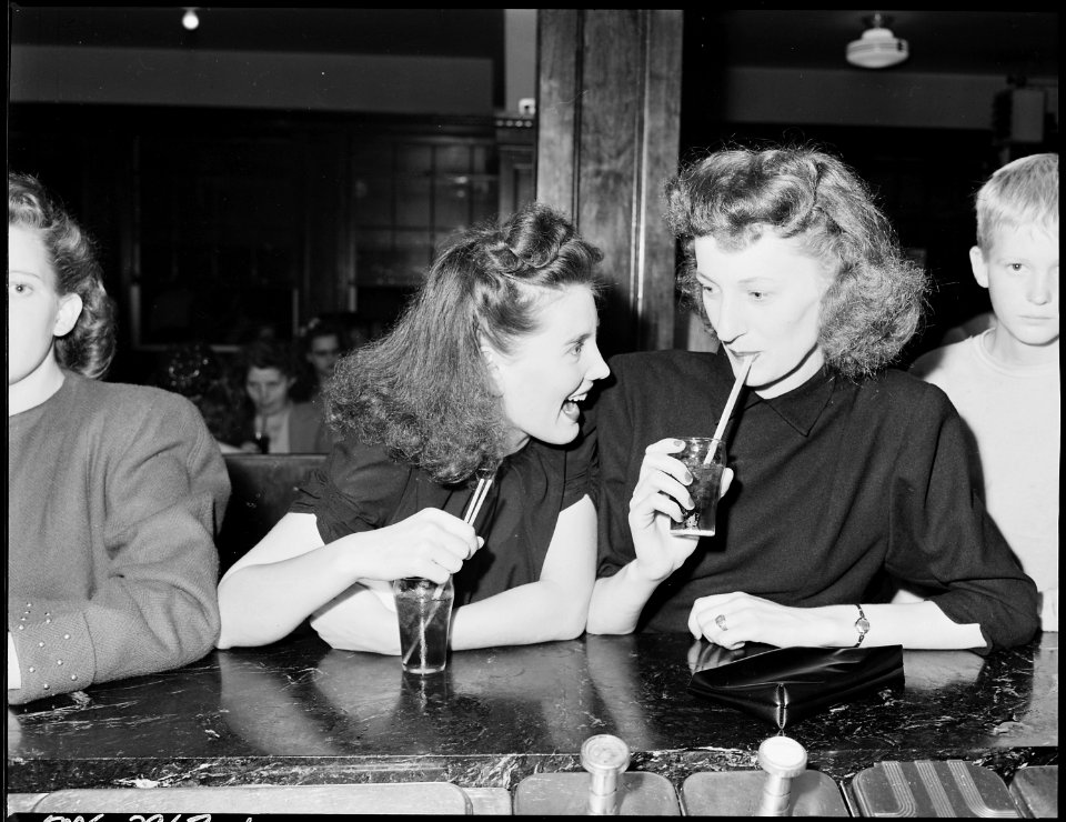Ella Jane Fain (right) daughter of Harry Fain, miner, and her cousin have a coke in soda fountain prior to movie... - NARA - 541426