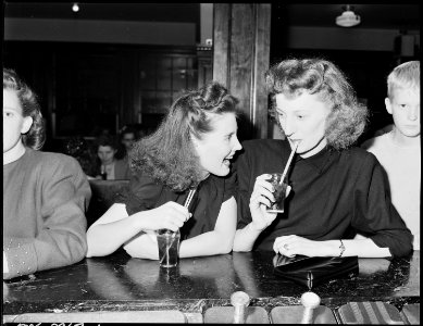 Ella Jane Fain (right) daughter of Harry Fain, miner, and her cousin have a coke in soda fountain prior to movie... - NARA - 541426