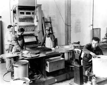 Employees working with the Automatic 16 Inch Powder Stacking Machine at the U.S. Hingham Naval Ammunition Depot during World War II