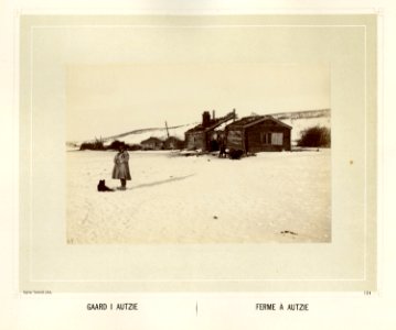 En same i pesk og skaller står ved en gård i Avzi-Autzie. En hund hviler i snøen - Norsk folkemuseum - NF.15006-118