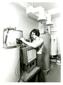 Engineering technician Robin Brese adjusting dials of energy of hot water heater1