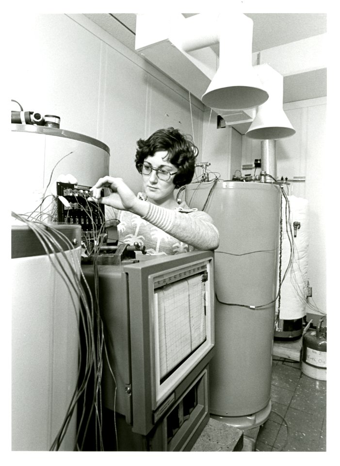 Engineering technician Robin Brese adjusting dials of energy of hot water heater