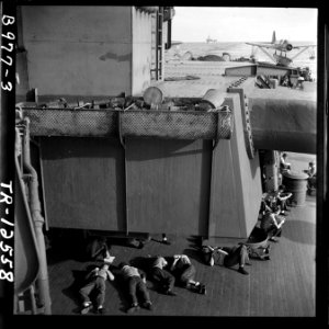Enlisted men relaxing during off-duty hours aboard the USS New Jersey (BB-62) OS2U's on catapults in background. - NARA - 520884