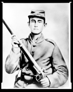 Enoch Hooper Cook, Jr., Pvt, Co. H. 38th Alabama Infantry, C.S.A., half-length portrait, facing front holding rifle LCCN2005695743