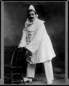 Enrico Caruso, 1873-1921, dressed as clown, holding back of chair, in Pagliacci LCCN2005680276