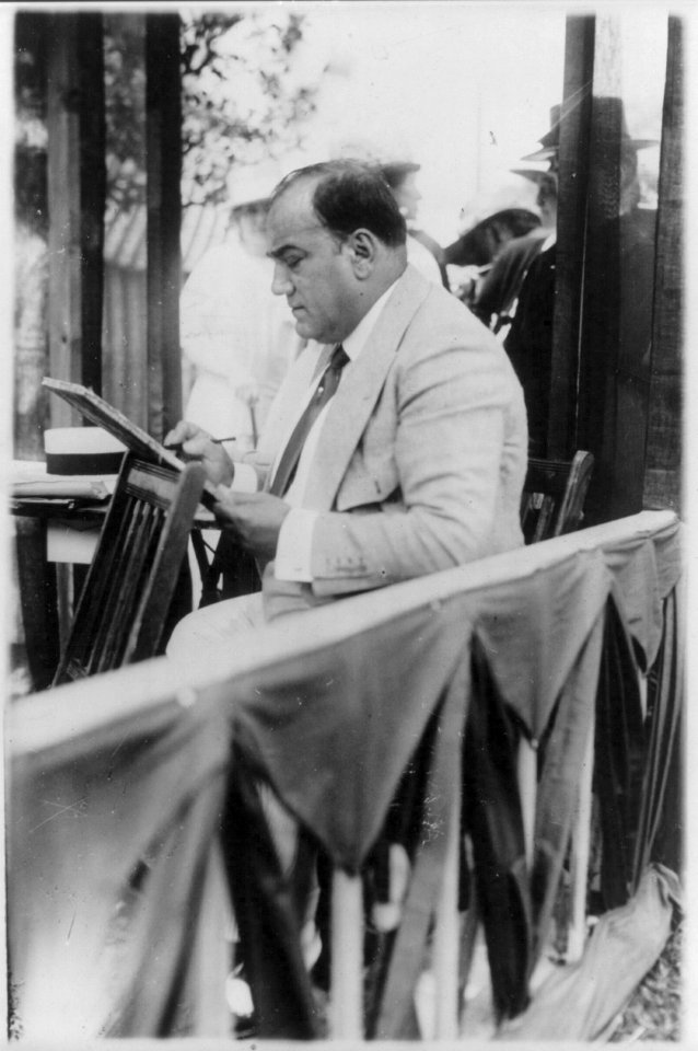 Enrico Caruso, 1873-1921, drawing caricature sketches in booth at charity fair in Southampton, L.I., left profile LCCN2005680287