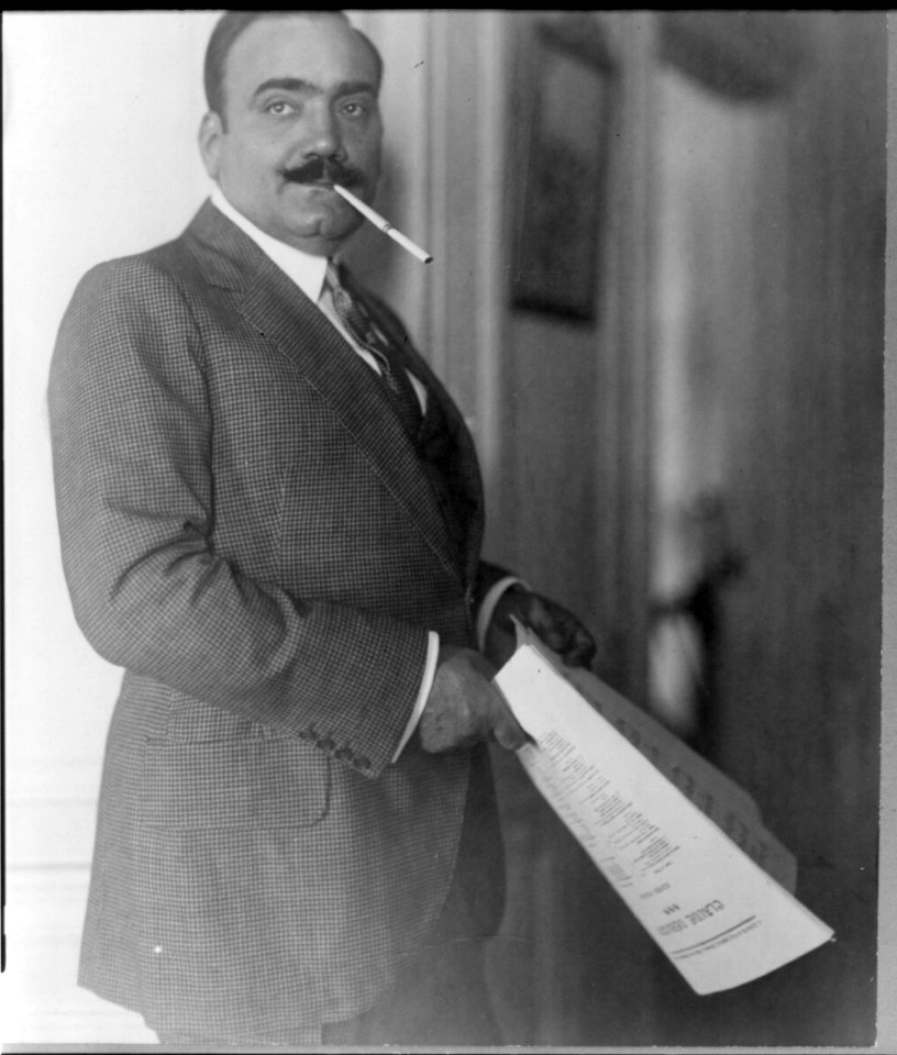 Enrico Caruso, 1873-1921, three-quarter length portrait, standing, facing right, cigarette in holder in his mouth LCCN2005680278