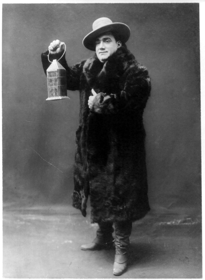 Enrico Caruso, 1873-1921, full-length portrait, standing, facing left, wearing fur coat and holding lantern LCCN2005680286