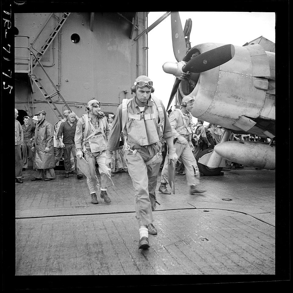 Ens. Charles W. Miller, Ltjg. Henry H. Dearing and Ltjg. Bus Alber (L-R) walking toward their planes on board USS... - NARA - 520887