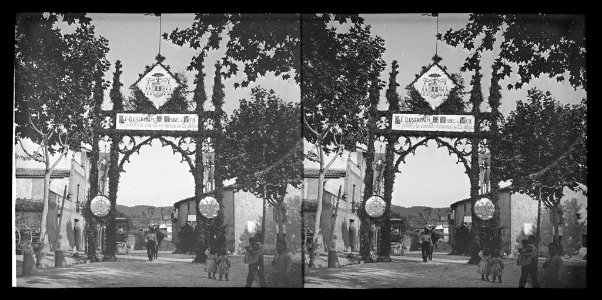 Entrada del poble decorada amb un arc de benvinguda al bisbe de Vic per a la processó i gent
