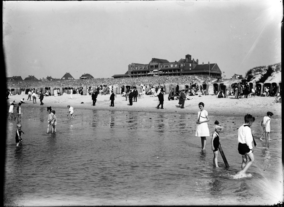 Gezicht op het strand van Bergen aan Zee vanaf het water, met op de voorgrond spelende kinderen en op de achtergrond de huizen aan de boulevard, de Pier Panderstraat en hotel Nassau Bergen - Regionaal Archief Alkmaar - FO1400117