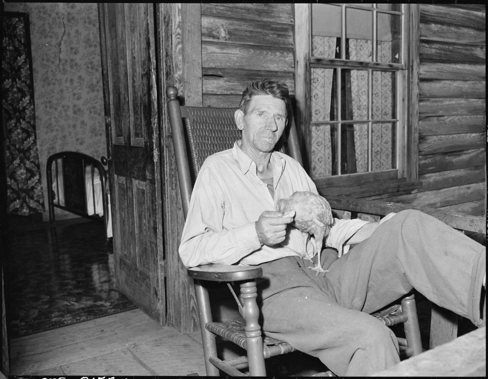 Gillie Wells on the front porch of his four room house for which he pays $7 monthly, he has recently moved into this... - NARA - 541146