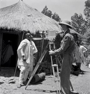 ETH-BIB-Reisebegleiter Mittelholzers mit Filmkamera vor Hütte-Abessinienflug 1934-LBS MH02-22-0654