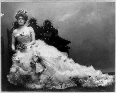 Ethel Barrymore, 1879-1959, full length portrait, seated, wearing long gown, bouquet in hands, facing slightly left LCCN2005692228