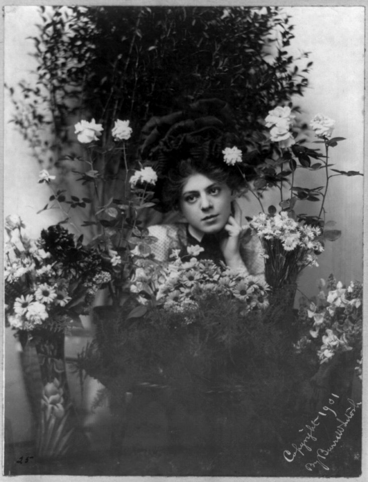 Ethel Barrymore, 1879-1959, head and shoulders portrait, left hand under chin, facing left, behind bouquets of flowers LCCN2005692227