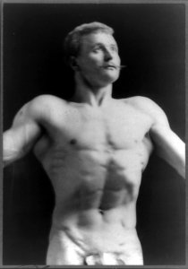 Eugen Sandow, half-length portrait, standing facing right, wearing fig leaf, looking upward LCCN91789157