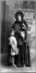 Evangeline Cory Booth, 1865-1950, standing, in Salvation Army dress, facing front; with 2 children LCCN2005688954