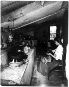 Evelyn, a little native maid (seated in kitchen with basket on her lap) LCCN2004665718