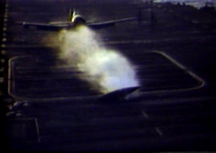 F6F-5N loses drop tank on landing aboard USS Bunker Hill (CV-17) in March 1945