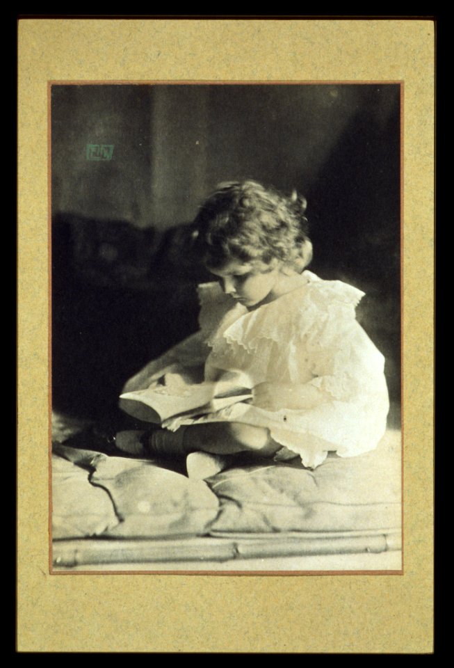 Girl sitting with legs folded, reading a book) - EW LCCN2004676251