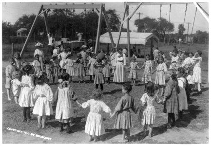 Girls' dodge ball game on school playground. Girls standing in circle and girl in middle holding ball LCCN2003655391 photo