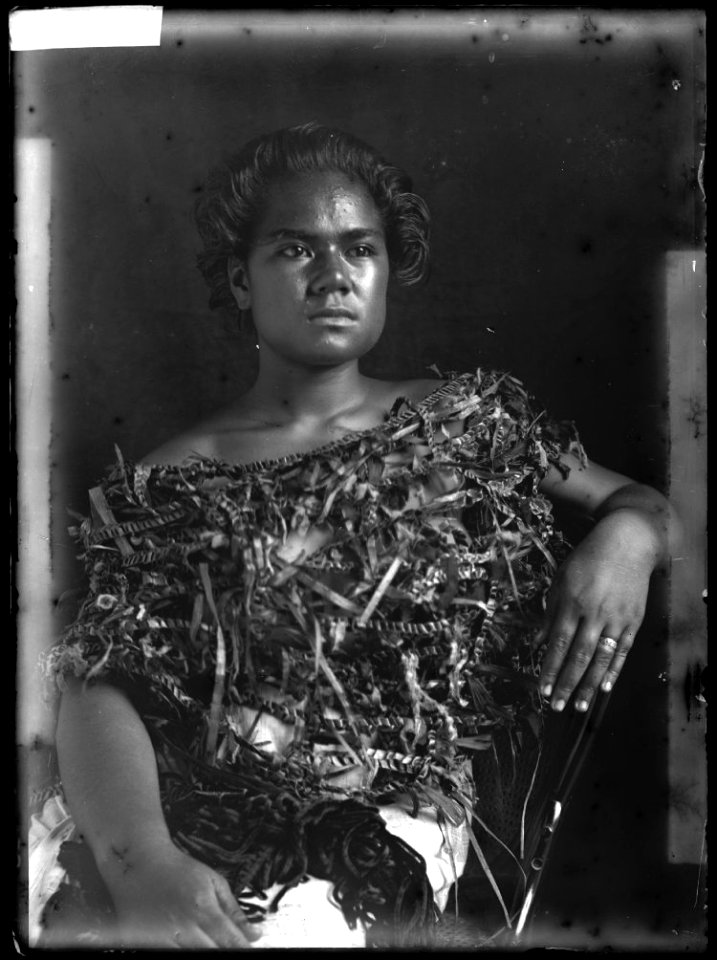 Glass negative (black and white); portrait of woman sitting on a western-style chair, wearing a plant fibre top; Oceania. Photographic process. Oc,G.N.1569, British Museum