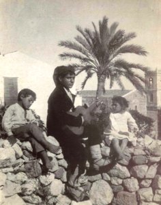 Gloeden, Wilhelm von (1856-1931) - n. 0606 - Ragazzo con chitarra davanti alla chiesa di San Domenico - Auch ich in Arkadien, p. 55