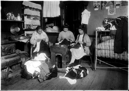 Family finishing pants. None of them spoke English. A neighbor's child said the young girl was 13 years old. In the... - NARA - 523527