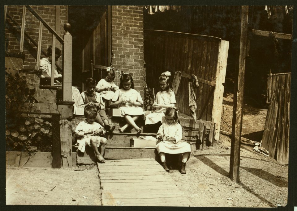 Family of Mrs. Donovan, 293 1-2 Highland Street, Roxbury, Mass., tying tags for Dennison Co. This is the family that has worked on tags for 7 years and makes an average from that work $30. LOC nclc.04249