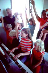 Family gathered around piano