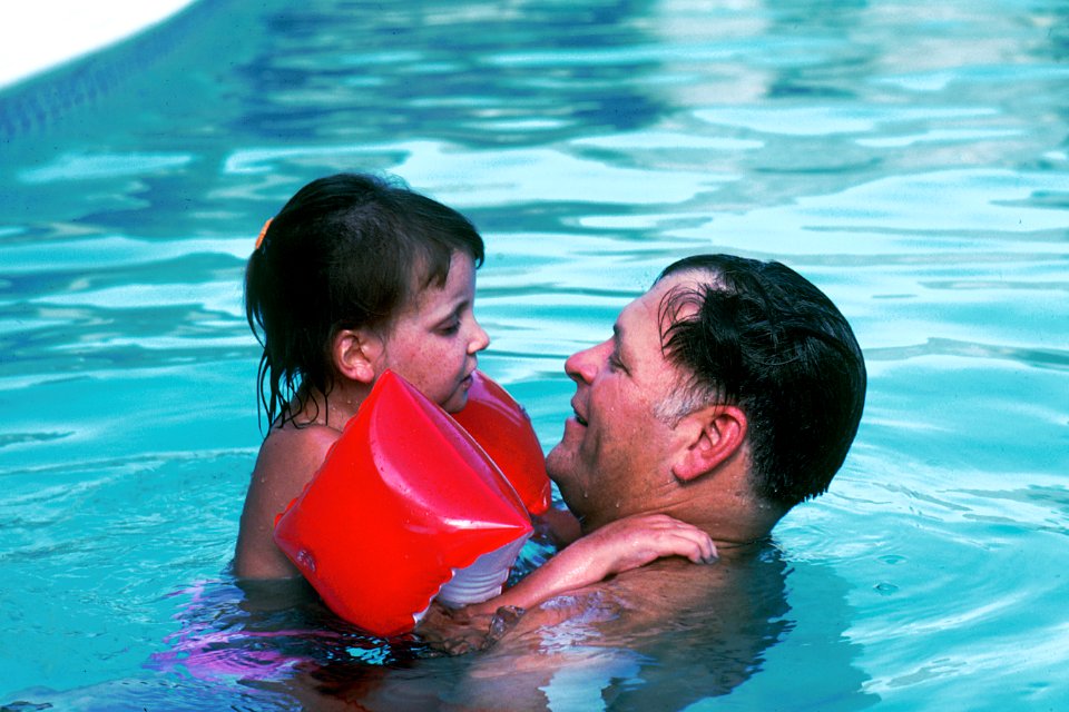 Father and daughter in a pool