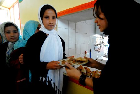 Fawzia passes a student a plate of food during lunch. (4510646203) photo