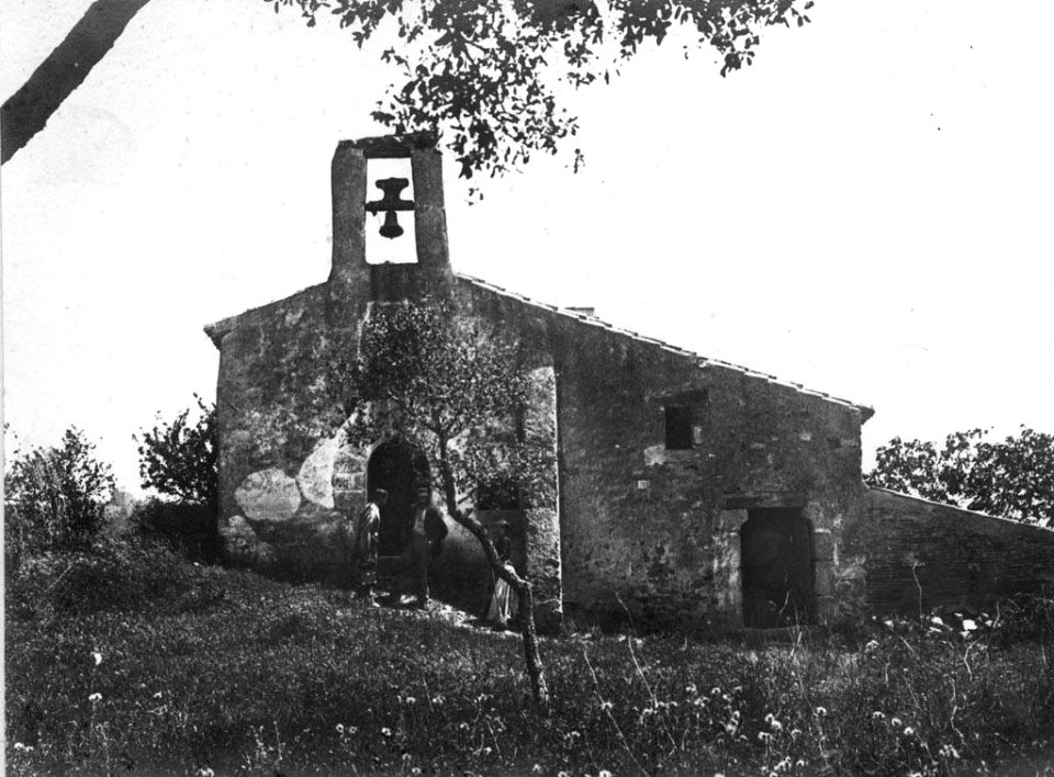 Façana de l'església Sant Pere de Vivelles de Palafolls amb gent