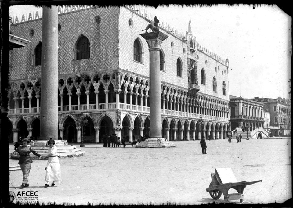 Façana del Palau ducal des de la plaça Sant Marc, amb dues dones en primer terme