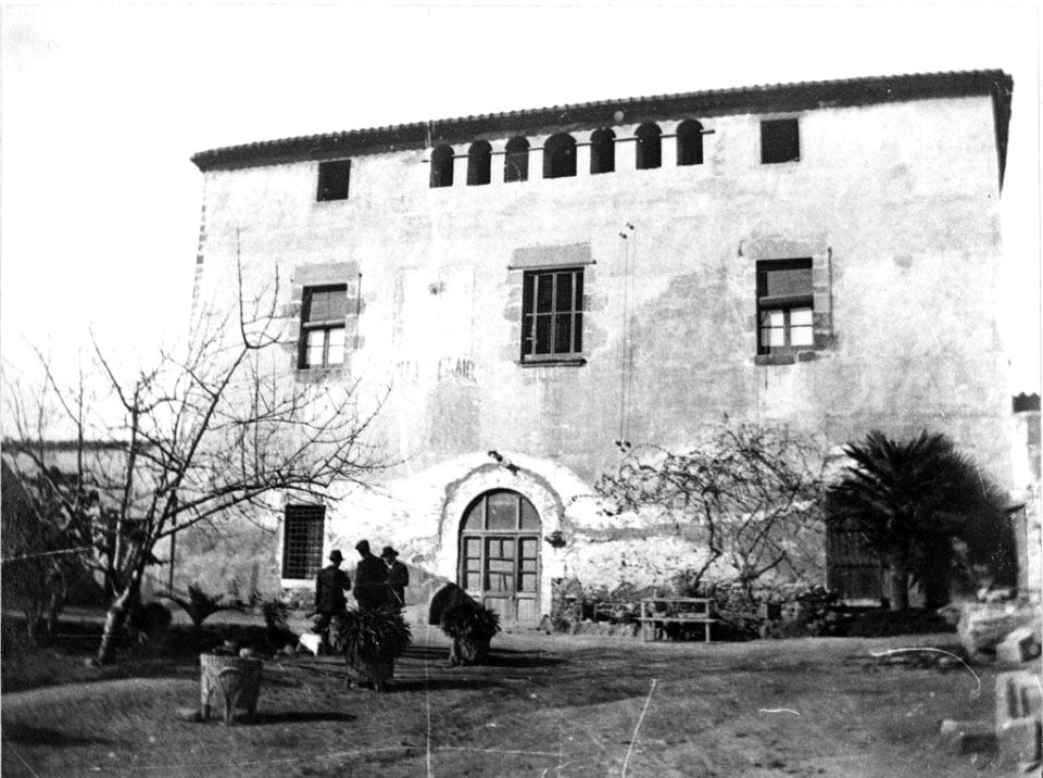 Façana i pati de Cal Gaig amb gent