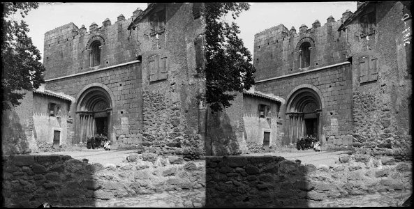 Façana i portal de l'església del monestir de Cornellà de Conflent amb un grup de gent