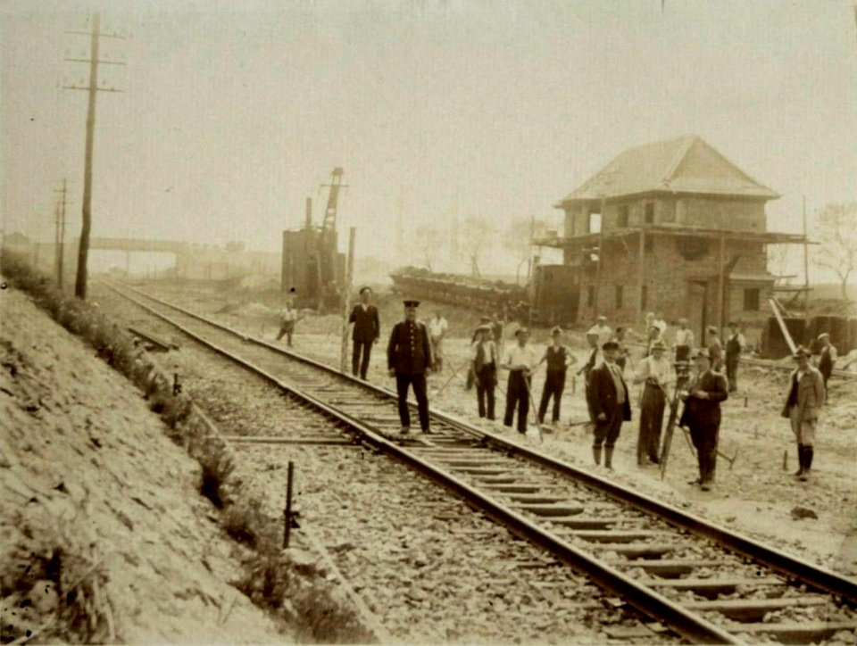 Feldbahn-Dampflok und Bagger auf einer Baustelle an einem Bahnhof